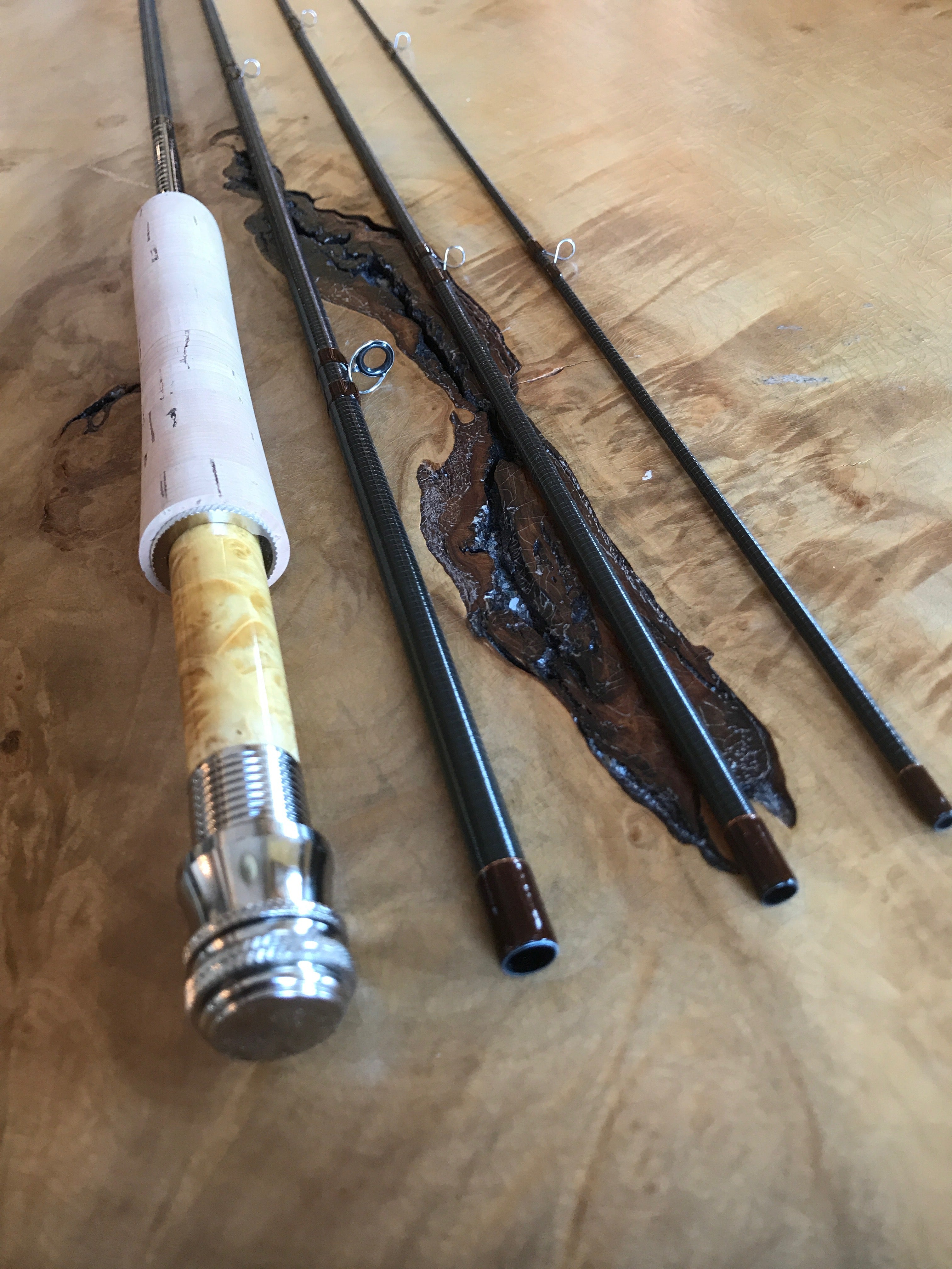 Livingston Rod Company YS Dry Fly graphite fly rod sections and reel seat displayed on burled wood surface -premium low-modulus graphite blank